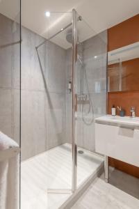 a glass shower in a bathroom with a sink at MiHotel Georges in Lyon