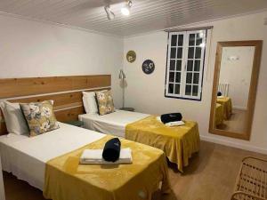 a hotel room with two beds and a mirror at Vacas Felizes Villas - Casa da Bilha in Rabo de Peixe