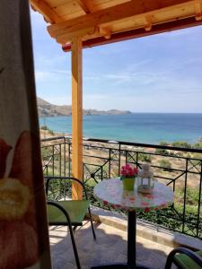 een tafel op een balkon met uitzicht op de oceaan bij Studios Edem in Agios Ioannis Kaspaka