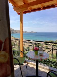 a table on a balcony with a view of the ocean at Studios Edem in Agios Ioannis Kaspaka