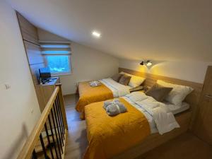 two beds in a room with yellow sheets at Vila Jahor Superior Apartman 16 “Minja” in Jahorina