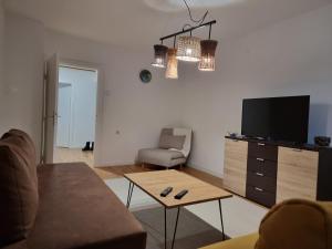 a living room with a couch and a tv and a table at Dino's spacious place in Sarajevo