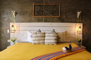Un dormitorio con una gran cama amarilla con almohadas en Casa Flora Handmade Hotel, en Atlixco