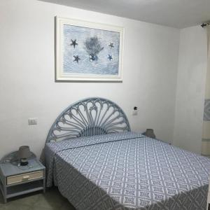 ein Schlafzimmer mit einem Bett und einem Bild an der Wand in der Unterkunft La Rosa Dei Venti in Olbia