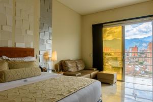 1 dormitorio con cama, sofá y ventana en Hotel Dorado La 70, en Medellín