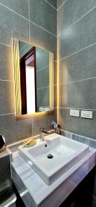 ein Badezimmer mit einem weißen Waschbecken und einem Spiegel in der Unterkunft Ain Sokhna 'Cosmopolitan'- Half-Board in Ain Suchna