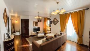 a living room with a couch and a television at Casa da Pedra in Lagoa