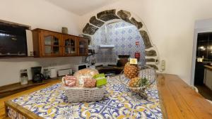 a kitchen with a table with fruit on it at Casa da Pedra in Lagoa