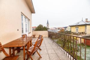 patio con mesa de madera y sillas en el balcón en Libušina Villa, en Kutná Hora