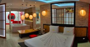 een slaapkamer met een bed en een badkamer met een bad bij Motel Le Monde (Adult Only) in Belo Horizonte