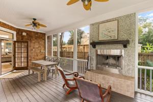 eine Veranda mit Kamin und Tisch und Stühlen in der Unterkunft Blue Crab Cottage - 307 Kelsall Ave in Kings Terrace