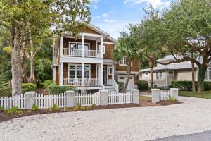 ein Haus mit einem weißen Gartenzaun in der Unterkunft Blue Crab Cottage - 307 Kelsall Ave in Kings Terrace
