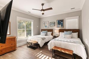 ein Schlafzimmer mit zwei Betten und einem Flachbildfernseher in der Unterkunft Astin Cottage - 4221 Seventh Street in Saint Simons + 36 Fotos