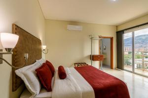 a bedroom with a bed and a large window at Hotel Dorado La 70 in Medellín