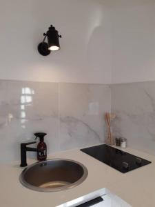 a sink in a kitchen with a light above it at Appartement avec piscine proche plages in Cap d'Agde +42 photos