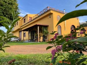 une maison jaune avec une voiture garée devant elle dans l'établissement Villa Fort Tenerife, à Tacoronte