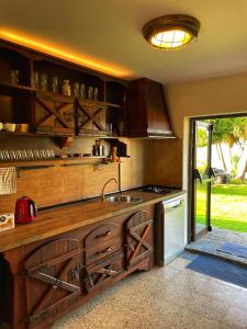 cocina con armarios de madera, fregadero y fogones en Villa Fort Tenerife, en Tacoronte