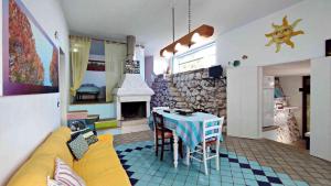 un soggiorno con divano giallo e tavolo di Il Giardino dei Tratturi - Con Splendida Vista sul mare e Piscina a Corsano