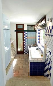 bagno con lavandino e piastrelle bianche e blu di Il Giardino dei Tratturi - Con Splendida Vista sul mare e Piscina a Corsano