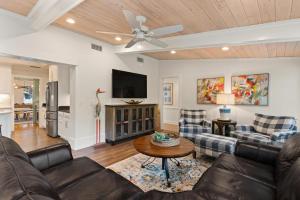 ein Wohnzimmer mit Sofa und Tisch in der Unterkunft The Southern Whippoorwill - 4226 Fifth Street in Saint Simons Island