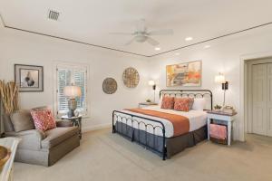 ein Schlafzimmer mit einem Bett, einem Sessel und einer Couch in der Unterkunft The Southern Whippoorwill - 4226 Fifth Street in Saint Simons Island + 27 Fotos