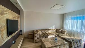 a living room with a large couch and a flat screen tv at Apartment City Center in Klaipėda