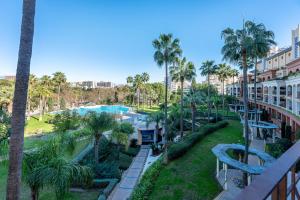 vista para a piscina num resort com palmeiras em 797 HOLIDAY RENTALS - BELLAGIO- Elegante piso para 6 a 1 min de la playa, con piscina interior y exterior, SPA con jacuzzi em Benalmádena