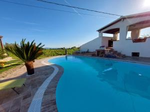 a swimming pool in front of a villa at Agriturismo B&B Domo De Resteblas in Berchidda