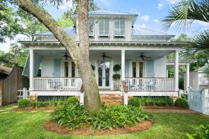a white house with a tree in the yard at Anastasia’s Burrow - 629 Oak St in Demere Park