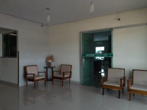 a group of chairs and a table in a room at Hotel Samambaia in Indiara 