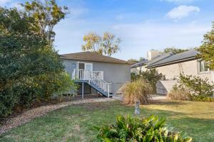 ein Haus mit einer Veranda und einem Hof in der Unterkunft Peachtree Cottage - 308 Peachtree Street in Kelvin Grove