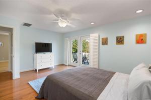 ein Schlafzimmer mit einem Bett und einem Flachbildfernseher in der Unterkunft Peachtree Cottage - 308 Peachtree Street in Kelvin Grove