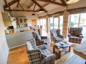 a living room with chairs and a table at The Cartshed, Sedbury Park Farm in Gilling