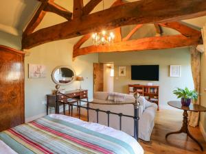 a bedroom with a bed and a living room at The Cartshed, Sedbury Park Farm in Gilling