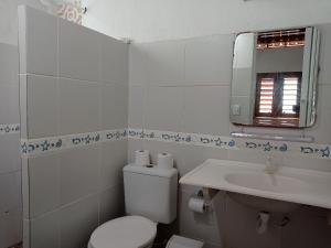 La salle de bains blanche est pourvue de toilettes et d'un lavabo. dans l'établissement Casa dos Ximenes - Beira Mar da Taíba - Ótima localização, à Taíba
