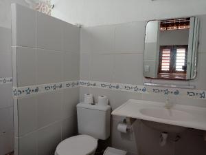 een witte badkamer met een toilet en een wastafel bij Casa dos Ximenes - Beira Mar da Taíba - Ótima localização in Taíba