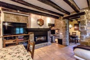 sala de estar con chimenea y TV en Catalunya Casas Stunning Costa Brava mountain retreat and 30kms away from the beach en Sant Feliu de Buixalleu