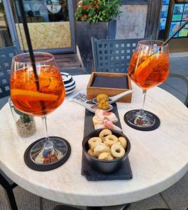 due bicchieri di vino e una ciotola di cibo su un tavolo di Apartments via Roma a Rovereto