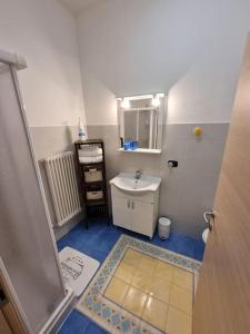 a small bathroom with a sink and a mirror at Apartments via Roma in Rovereto