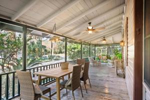 eine abgeschirmte Veranda mit Tisch und Stühlen und einem Deckenventilator in der Unterkunft Palmetto Cottage - 116 Florence Street in King City