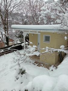 ein Haus mit schneebedecktem Dach im Schnee in der Unterkunft The Bungalow in Braşov