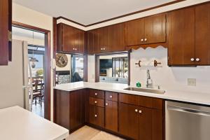 uma cozinha com armários de madeira e bancadas brancas em This is It - 4314 Sixteenth Street em Saint Simons Island