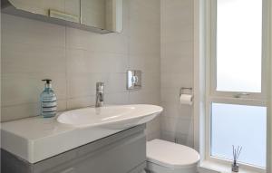 La salle de bains blanche est pourvue d'un lavabo et de toilettes. dans l'établissement 4 Bedroom Cozy Home In Fitjar, à Fitjar