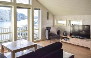 - un salon avec une télévision, un canapé et une table dans l'établissement 4 Bedroom Cozy Home In Fitjar, à Fitjar