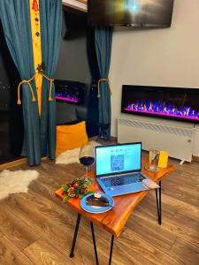 um computador portátil sentado numa mesa numa sala de estar em Tiny House Retreat Bran em Bran