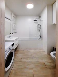 a bathroom with a sink and a washing machine at Primavera - Apartament nad rzeką - parking w cenie in Wrocław