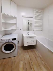 a white bathroom with a washing machine and a sink at Primavera - Apartament nad rzeką - parking w cenie in Wrocław