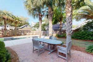 a table and two chairs and a tree in a yard at Latitude Adjustment - 4311 Ninth Street in Saint Simons Island