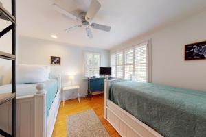 a bedroom with a bed and a ceiling fan at Latitude Adjustment - 4311 Ninth Street in Saint Simons Island +21 photos