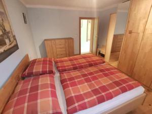 1 dormitorio con 1 cama con colcha a cuadros en Ferienwohnung Konrad, en Kirchdorf in Tirol